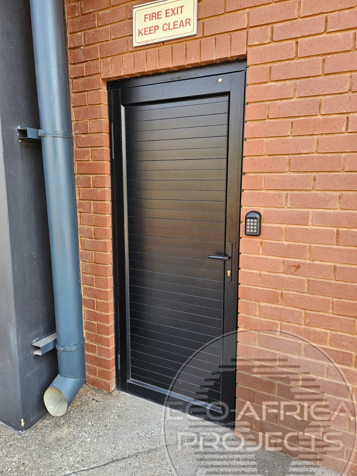 Solid cladding aluminium entrance door in a brick wall