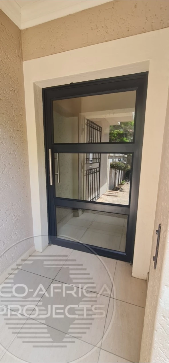 Custom charcoal aluminium entrance door with three glazed panels and a stainless steel pull handle