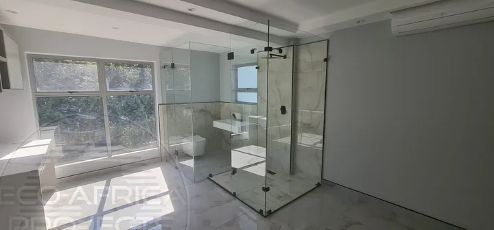Frameless glass shower enclosure in a finished home bathroom