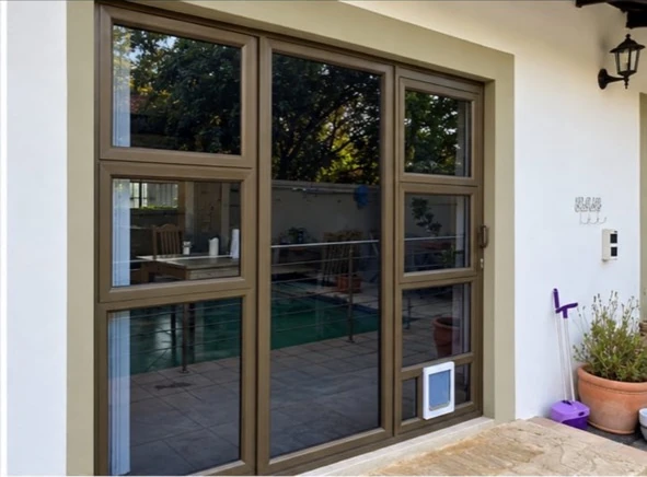 Bronze aluminium glazed doors with an integrated pet access flap in the lower panel